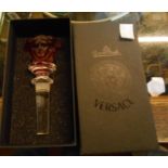 A boxed Versace Rosenthal glass bottle stopper with red mask top