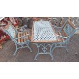 A cast iron table and two patio chairs - sold with an iron chair back