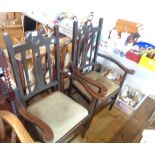 A pair of early 20th Century stained oak framed elbow chairs with pierced splat backs and