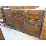 A 1.87m antique stained pine shop fitting with three flights of six drawers (one missing), all