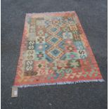 A 20th Century hand made Kelim with faded polychrome prism and hook decoration - 1.58m X 1.02m