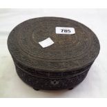 An antique Anglo Indian carved ebony oval box with hinged lid, sitting on small bun feet with all