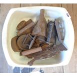 A bowl containing a selection of old flat irons including miniature, weights, etc.