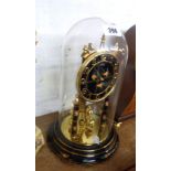 A vintage Kundo decorative anniversary clock with floral decoration on black ground, ball pendulum
