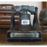 A cast metal model of the Liberty Bell on wooden plinth