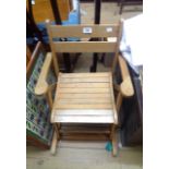 A vintage blonde wood folding child's elbow rocking chair with slatted seat panel