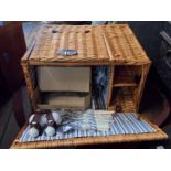 A wicker picnic basket with fitted contents