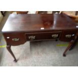 A 1.07m Edwardian walnut dressing table with three frieze drawers, set cabriole legs with pad feet -