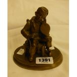 A 19th Century French brass figurine featuring a young boy playing with a pair of bellows