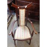 An early 20th Century stained walnut framed elbow chair with upholstered back and seat, set on