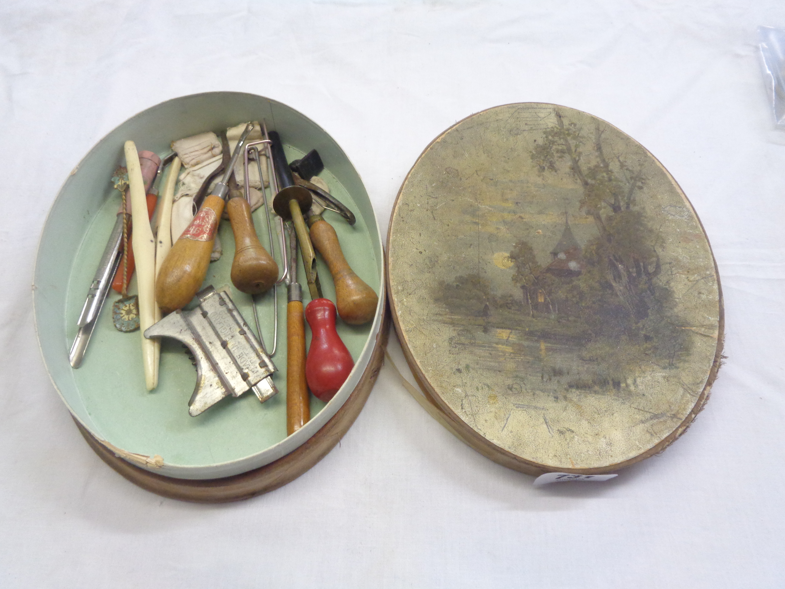 An old Cadbury's chocolate box containing assorted sewing implements, etc.