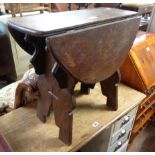 A 61cm old oak swivel-top table, set on ecclesiastical standard ends