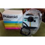 A vintage Polaroid 1000 land camera with instruction and boxed Polaroid flash