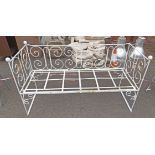 An old wrought iron garden bench of square form with finials to corner - one finial missing