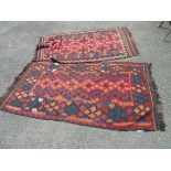Two 20th Century Pakistani kilims with similar repeat geometric designs on russet ground - both