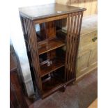 An early 20th Century polished oak revolving bookcase with slatted dividers, set on quadruple legs