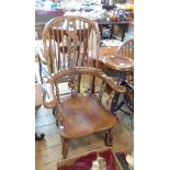 An antique yew and elm Windsor hoop stick back elbow chair with pierced splat and solid elm