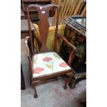 An Edwardian stained walnut framed Queen Anne style elbow chair with upholstered seat, set on