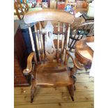 An old elm and beech spindle and splat back rocking chair with moulded solid seat, set on turned