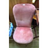 A Victorian high back nursing chair with old rose coloured velour upholstery, set on turned front