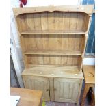 A 1.11m 20th Century waxed pine two part dresser with two shelf open plate rack over a base with