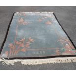 A 20th Century Chinese washed wool rug with perching bird, pagoda, bamboo and other motifs on pale