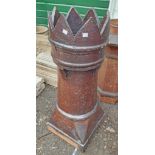 A large salt glazed stoneware chimney pot with castellated top