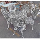 A vintage cast aluminium patio set of four chairs and table with remains of painted finish