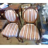 A pair of late Victorian carved walnut framed oval panel back standard chairs with striped