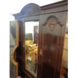 A 1.6m Edwardian stained walnut triple wardrobe with break arch cornice, central bevelled mirror