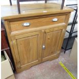 A 90cm modern polished pine dresser base with long frieze drawer over double cupboard, set on