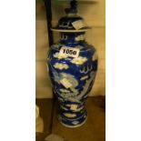 An antique blue and white Chinese porcelain lidded vase decorated with dragons amongst the