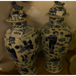 A pair of antique Chinese porcelain lidded vases decorated all over in a blue palette with