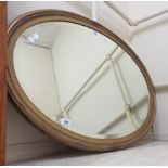 A 94cm vintage gilt framed bevelled oval wall mirror