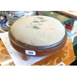 A Victorian stained wood circular footstool with tapestry upholstery, set on turned feet