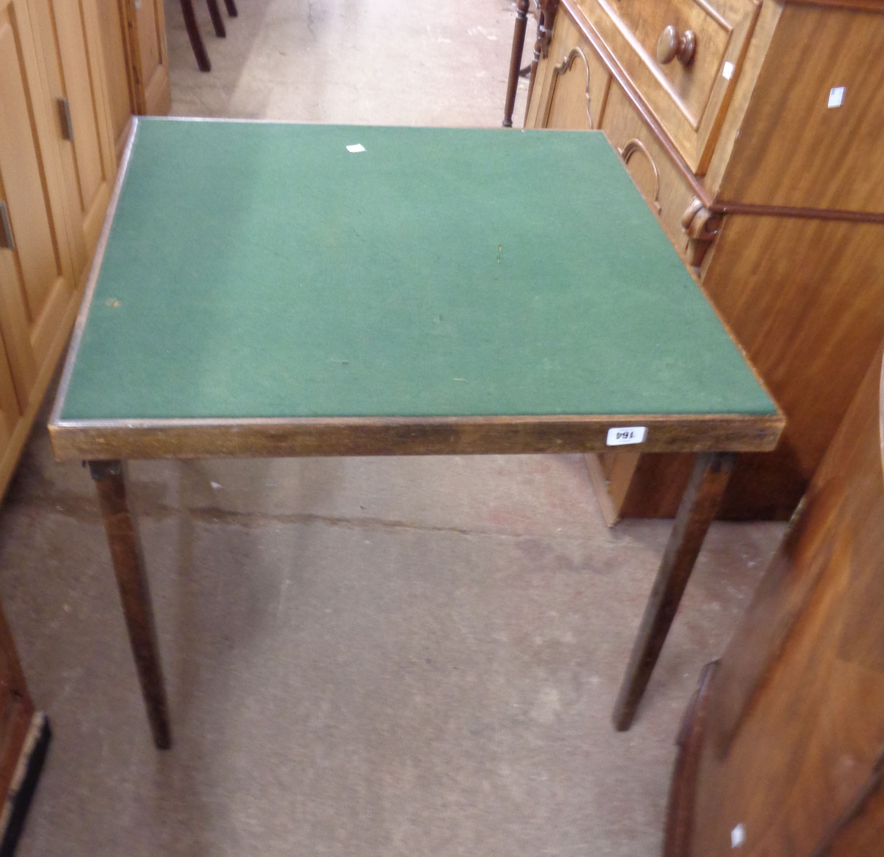 A vintage stained wood framed card table with baise inset top and folding legs
