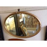 An early 20th Century gilt framed bevelled oval wall mirror - some loss to applied floral
