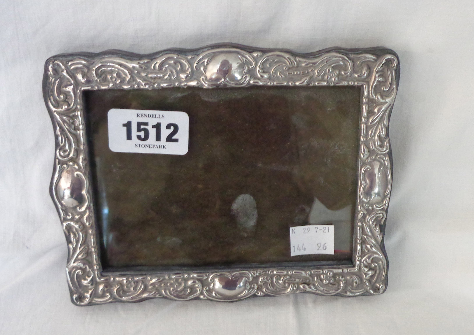 A continental 90 grade white metal fronted photograph frame with embossed decoration and stained