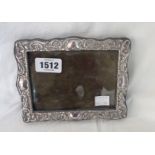 A continental 90 grade white metal fronted photograph frame with embossed decoration and stained