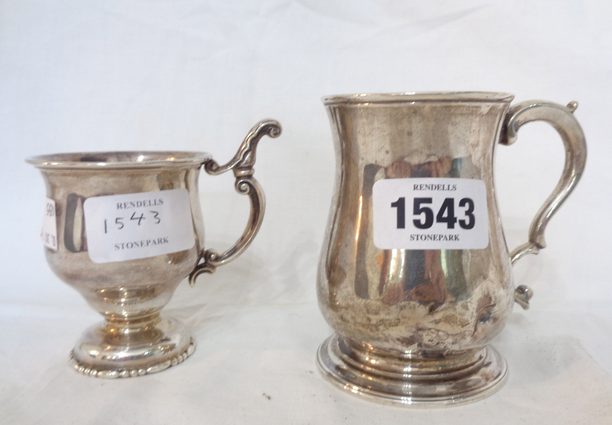 A silver footed cup with ornate cast scroll handle - sold with a small silver baluster tankard -