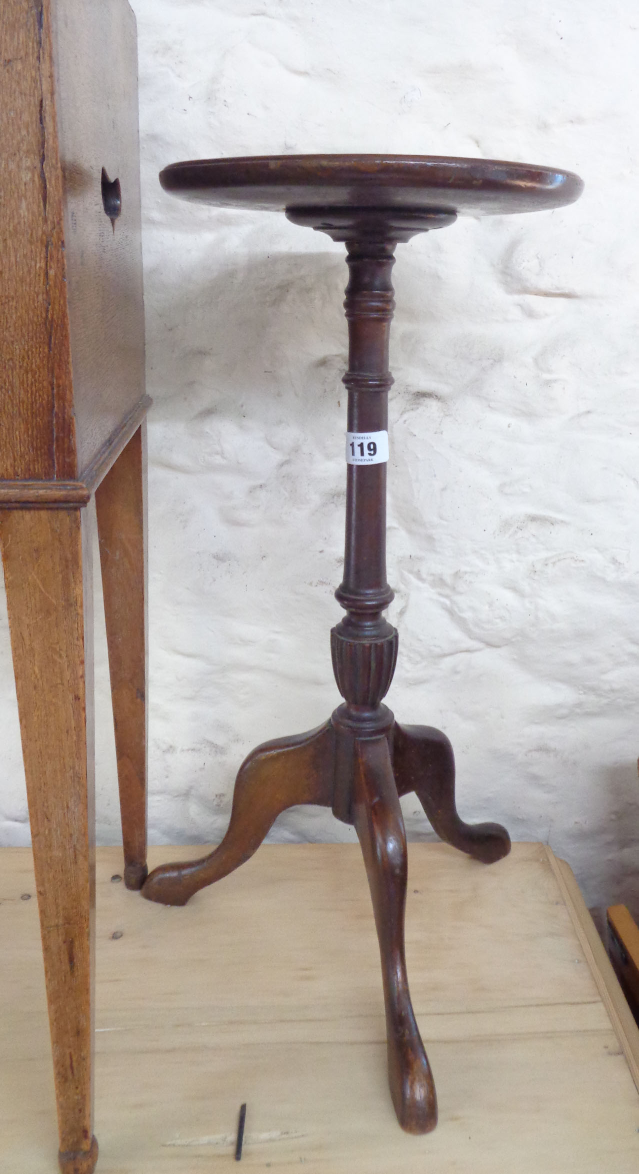 A reproduction mahogany pedestal wine table, set on turned pillar and tripod base