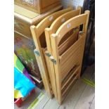 Three matching blond wood folding chairs with slatted seats