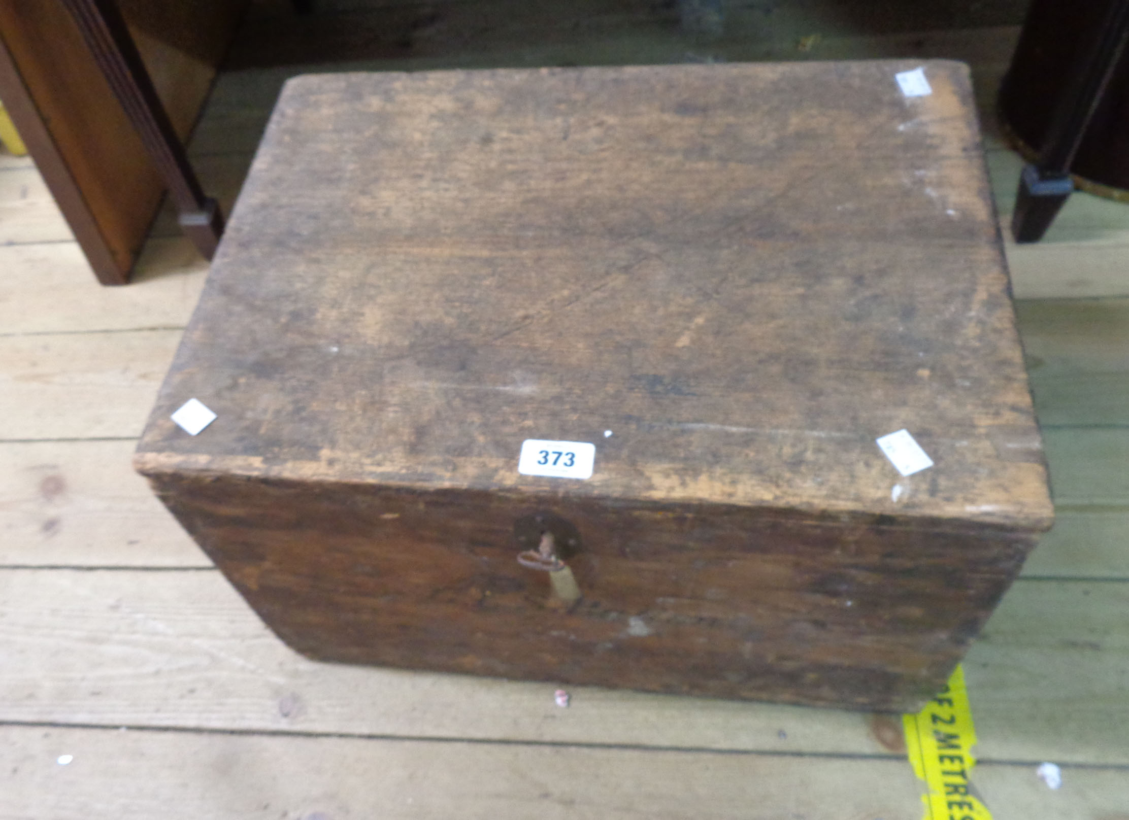 An antique pine tuck chest with flanking iron drop handles and key