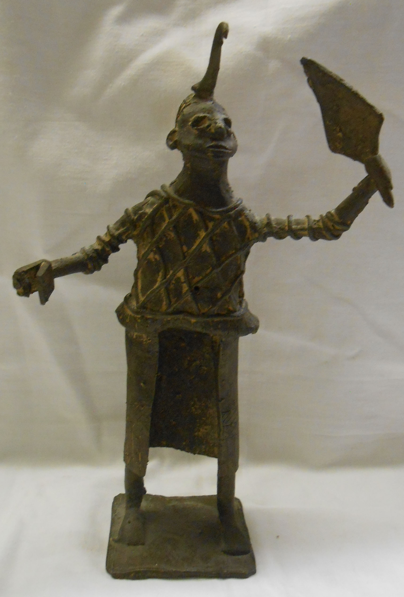 An African cast bronze figure depicting a man with horned headdress