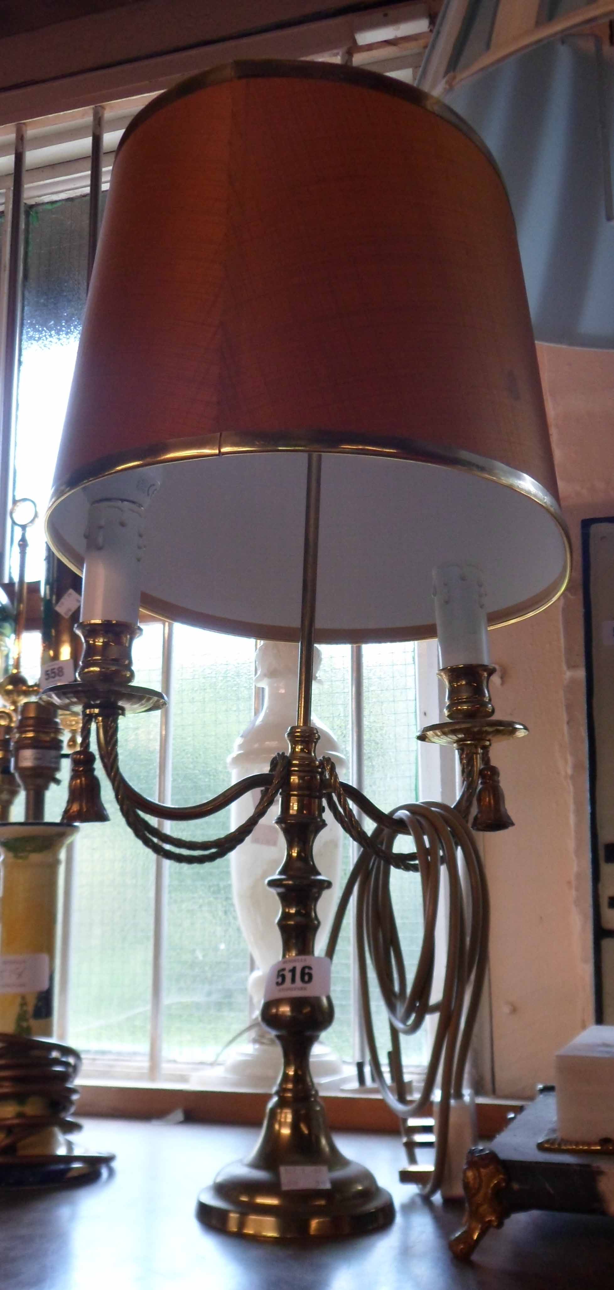 A cast brass table lamp in the form of a twin branch candelabra - with shade