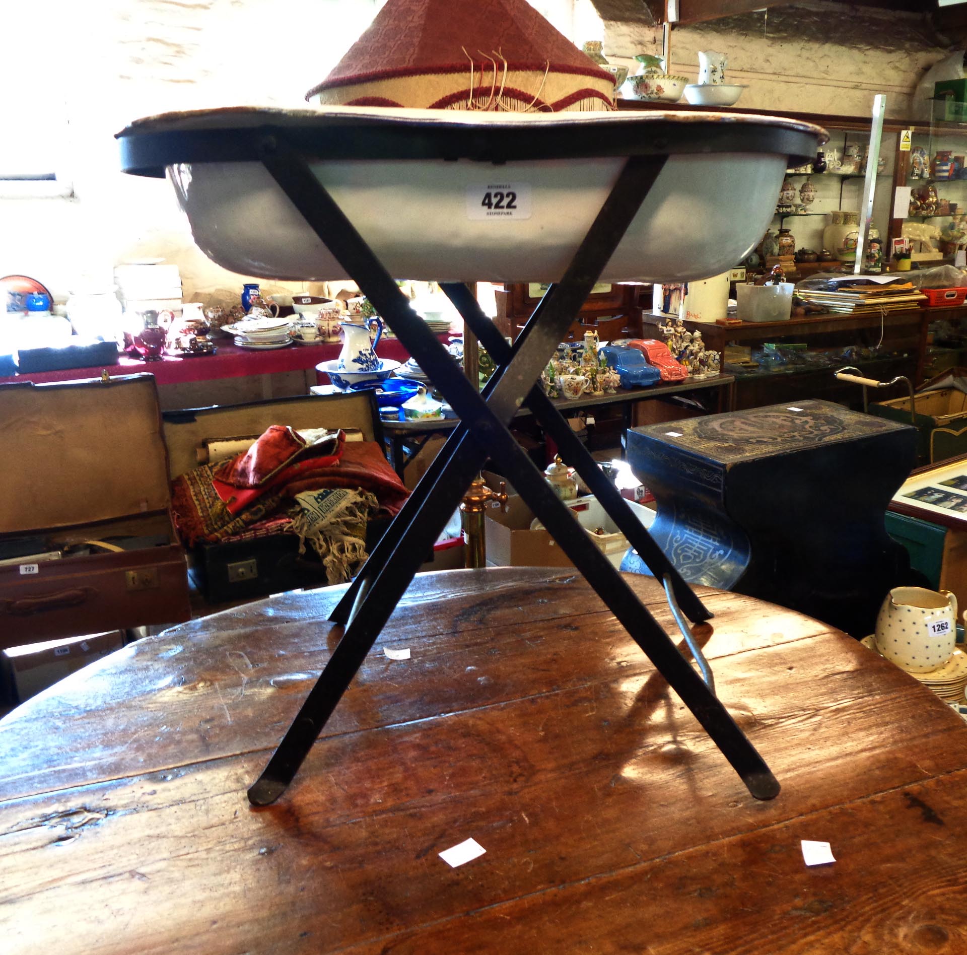 A vintage enamelled bidet, on folding metal stand