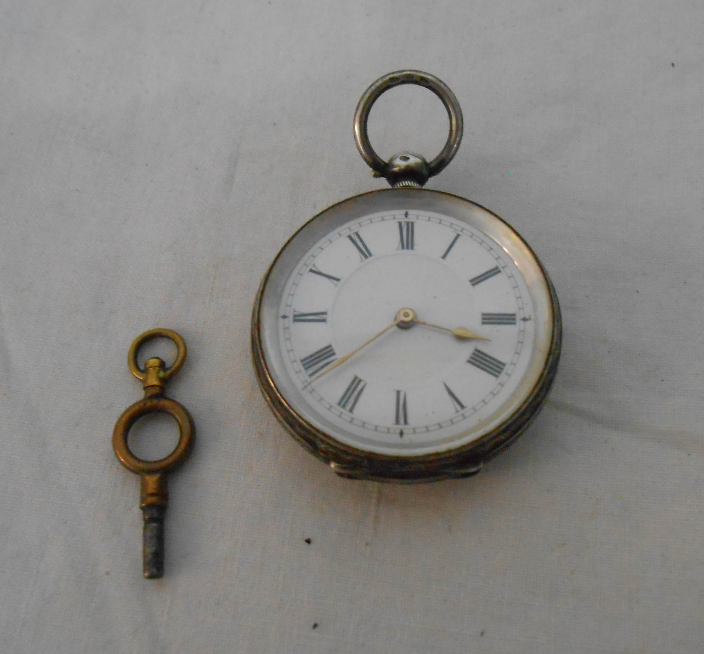 A silver cased lever fob watch with engraved decoration and key