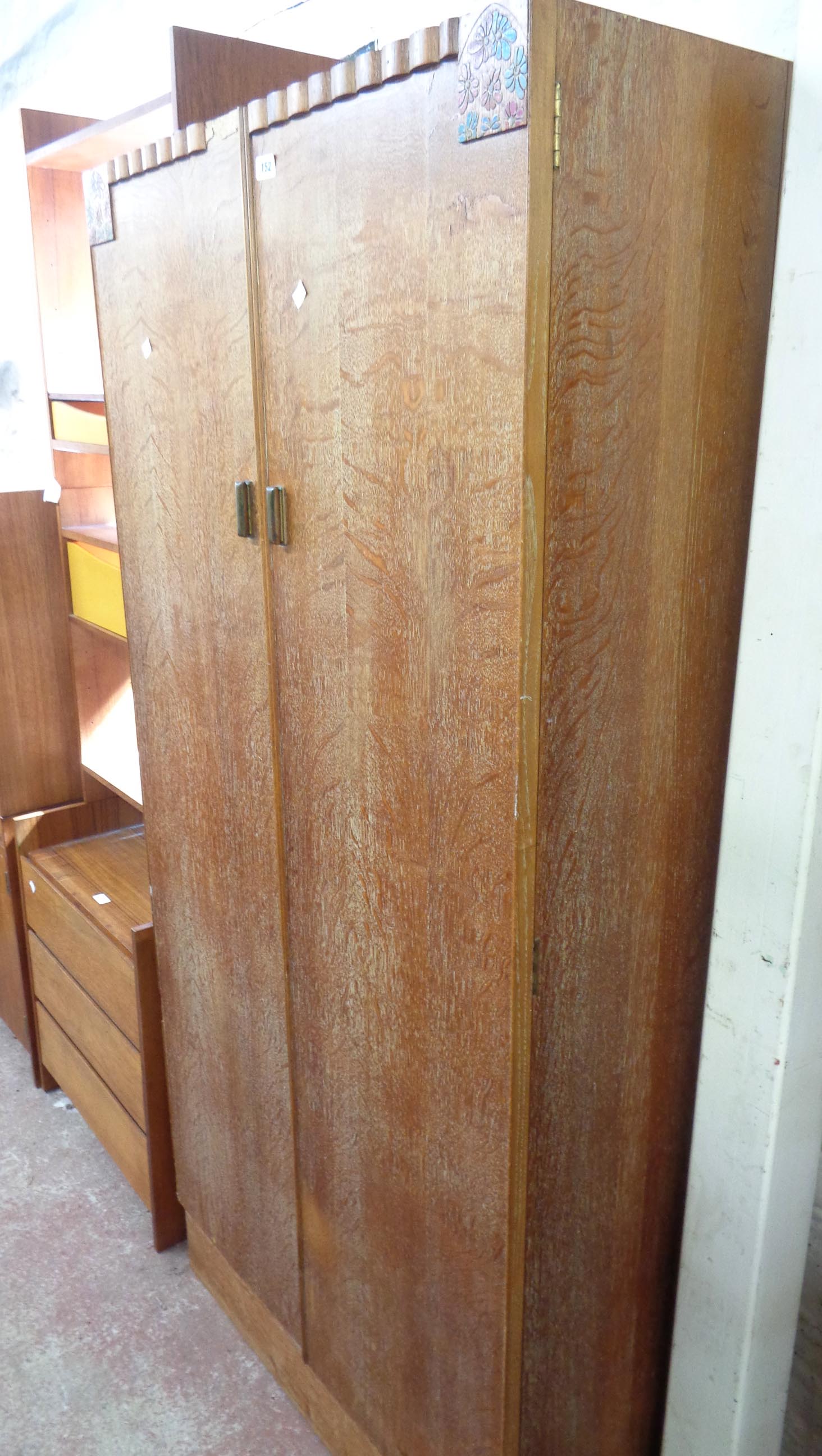 An 84cm Art Deco limed oak double wardrobe with hanging space and shelves, set on plinth base -