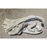 A concrete garden statue of a sleeping fallen angel