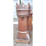 A large salt glazed stoneware chimney pot with castellated top